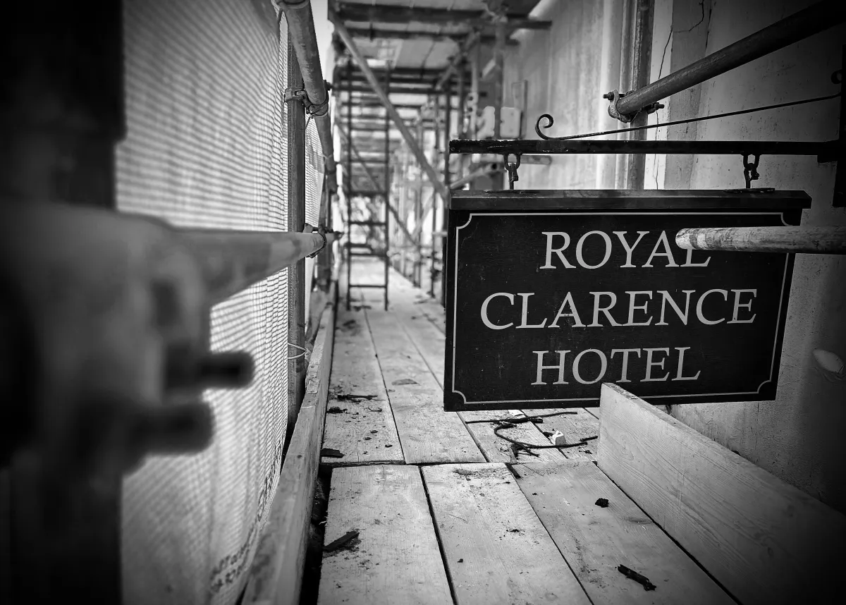 The Royal Clarence Hotel sign hanging on the scaffolding